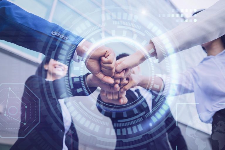 Group of people joining hands with a digital overlay of technology elements.